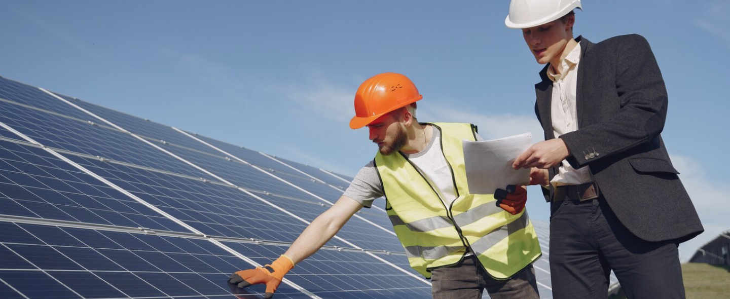 Two Guwing Green team members reviewing a solar install on site